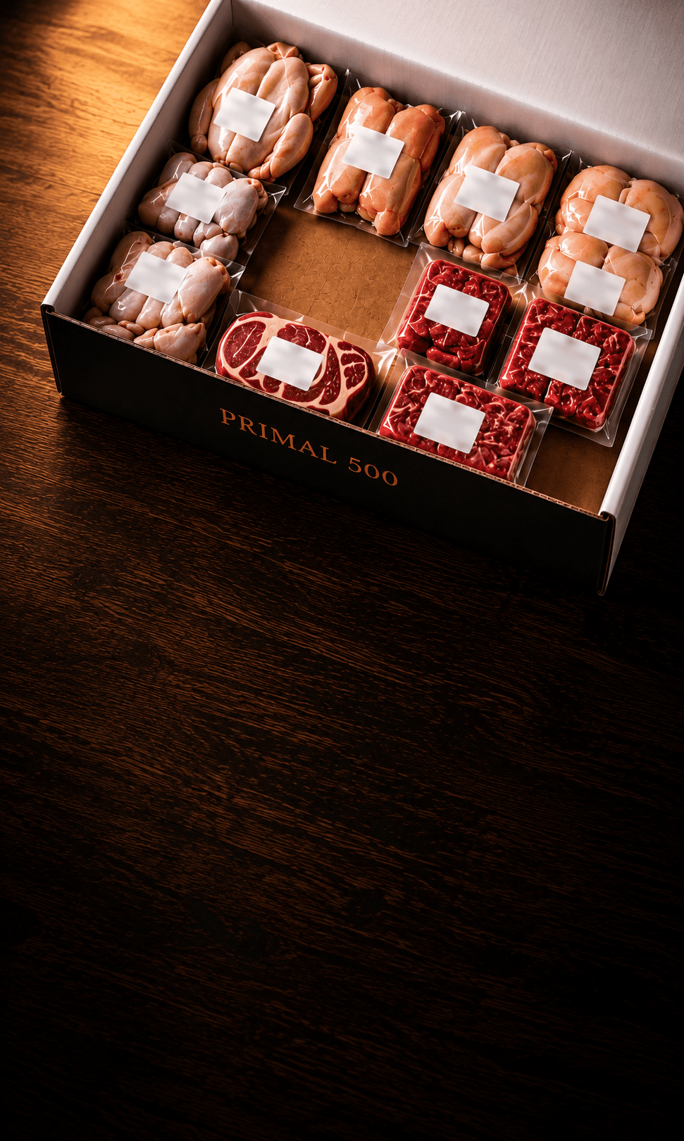 The Primal 500 Founding Member Box: a whole chicken, chicken thighs, breasts and wings, grass-fed ground beef, a regenerative sirloin, ribeye and sausage, each vacuum-sealed and labeled.
